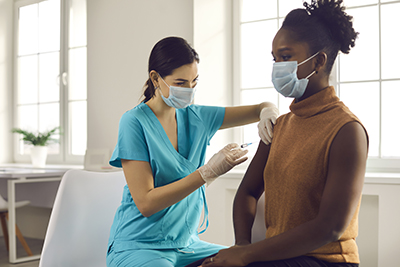 nurse vaccinating a black woman