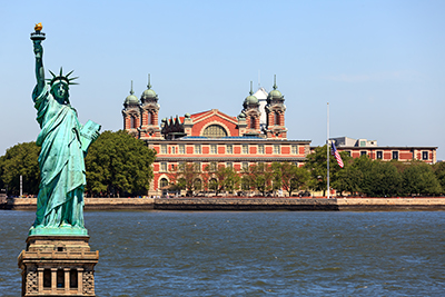 Statue of Liberty in front of Ellis Island