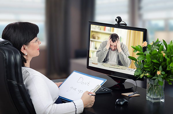 female counselor doing online counseling behind computer screen